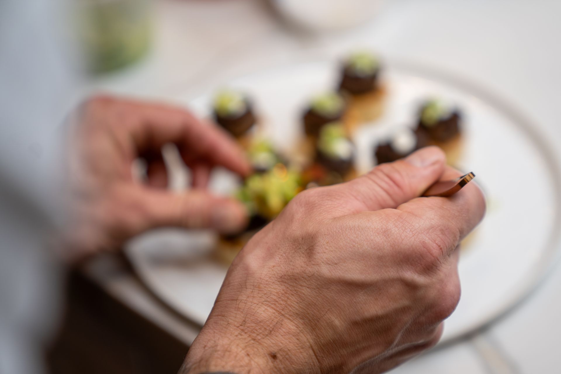 A person is holding a fork over a plate of food.