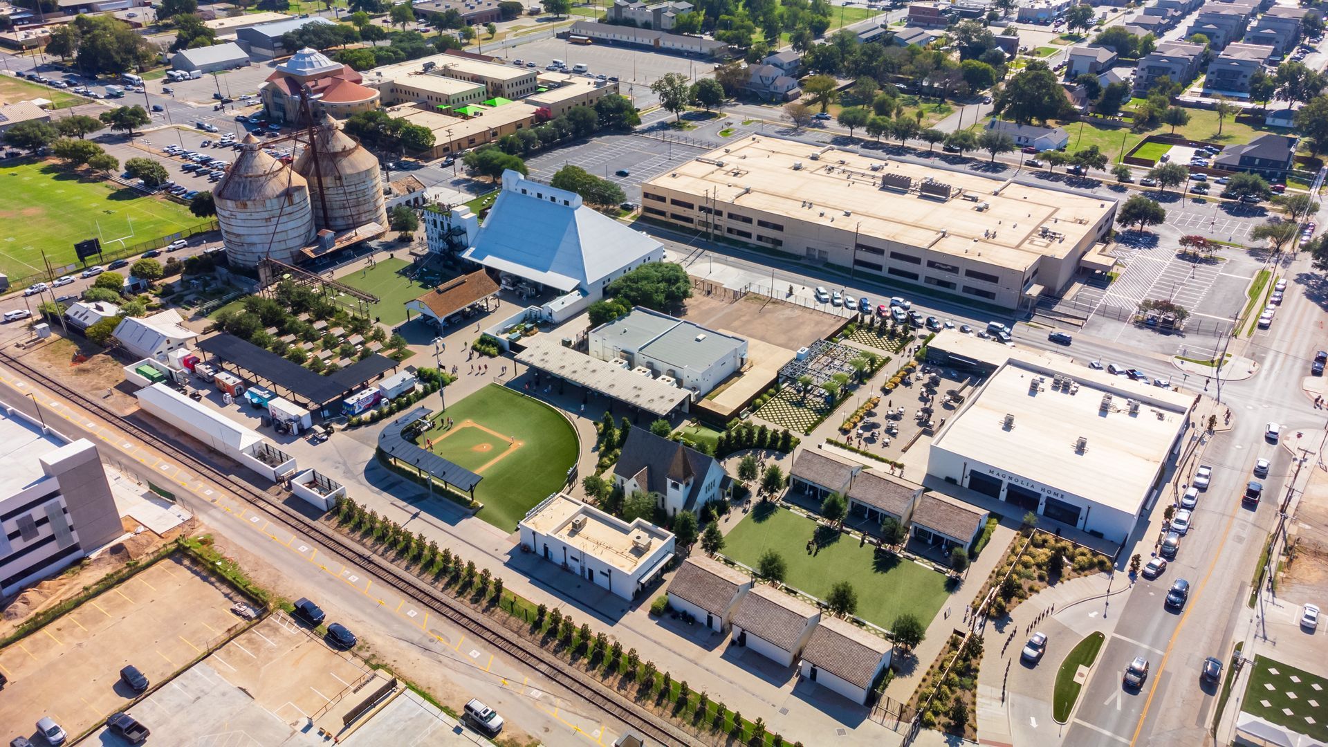 An aerial view of a city with a lot of buildings and a train track.