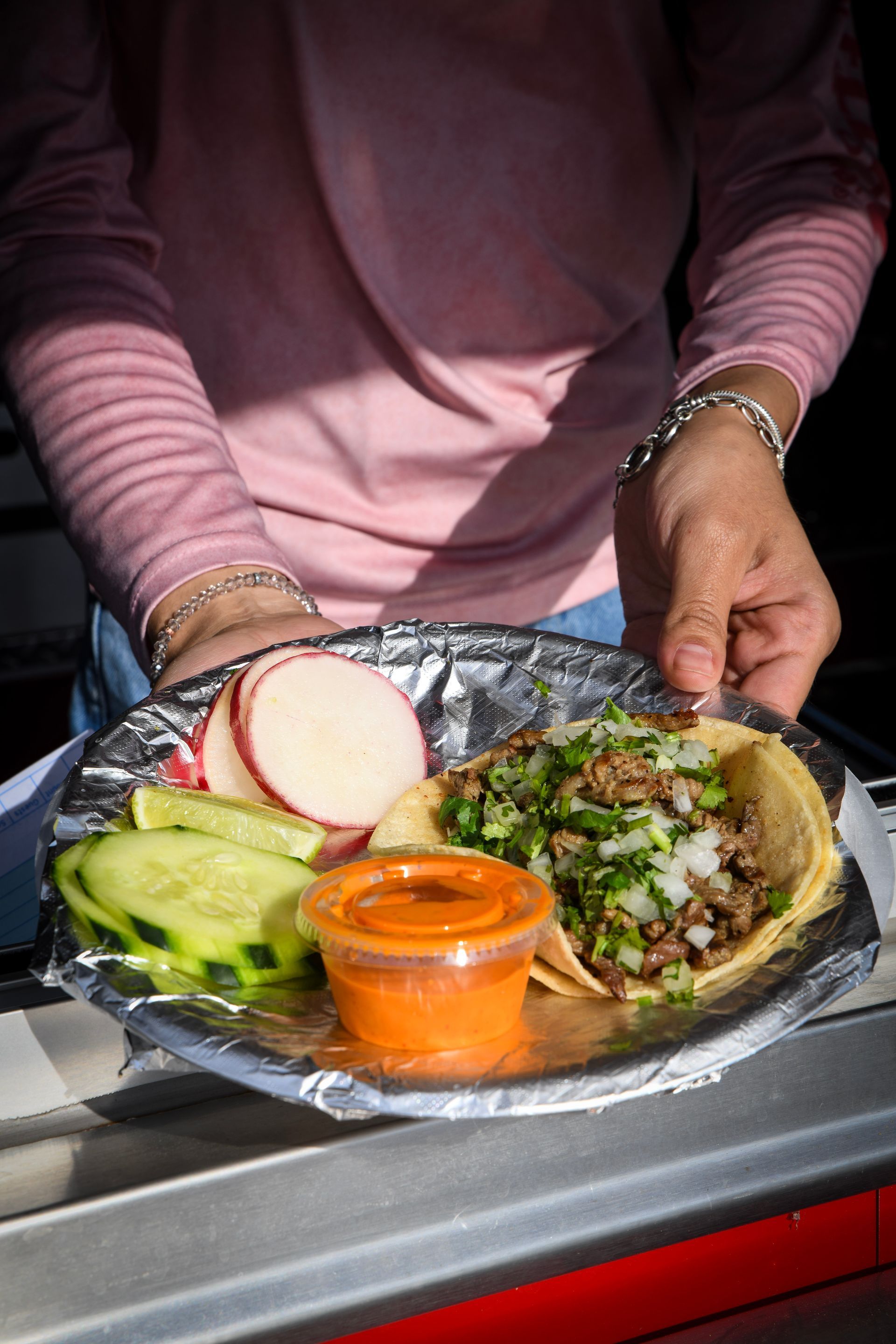 A person is holding a plate of food with a taco on it.