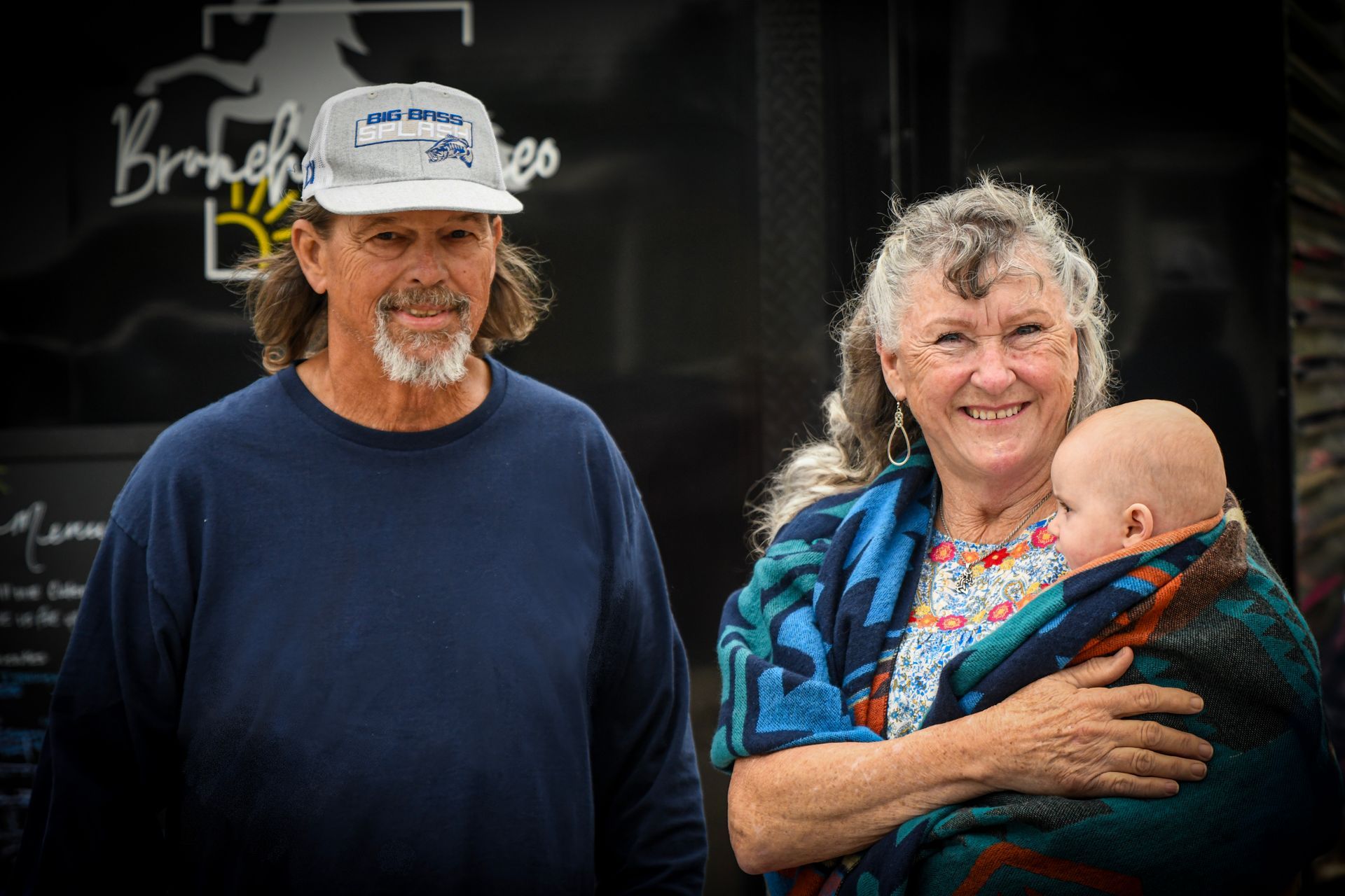 A man and a woman are standing next to each other holding a baby.