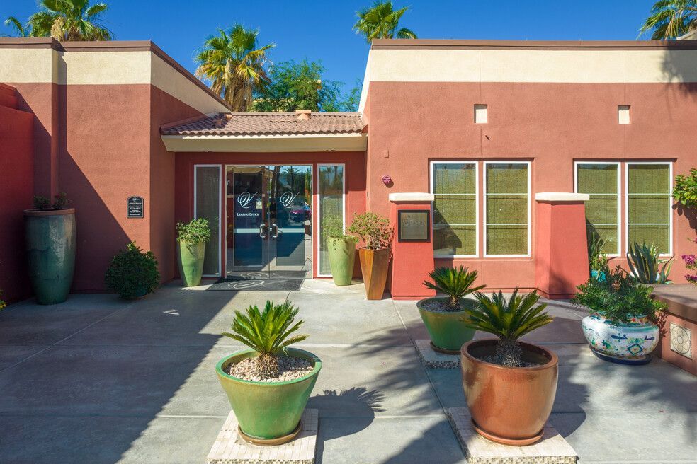 A red building with a lot of potted plants in front of it