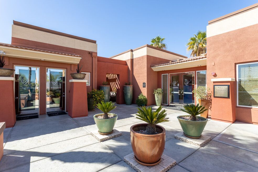 A large building with a lot of potted plants in front of it.