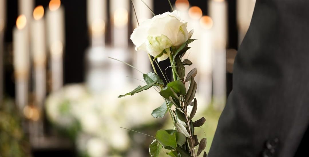 person holding a flower in front of candles