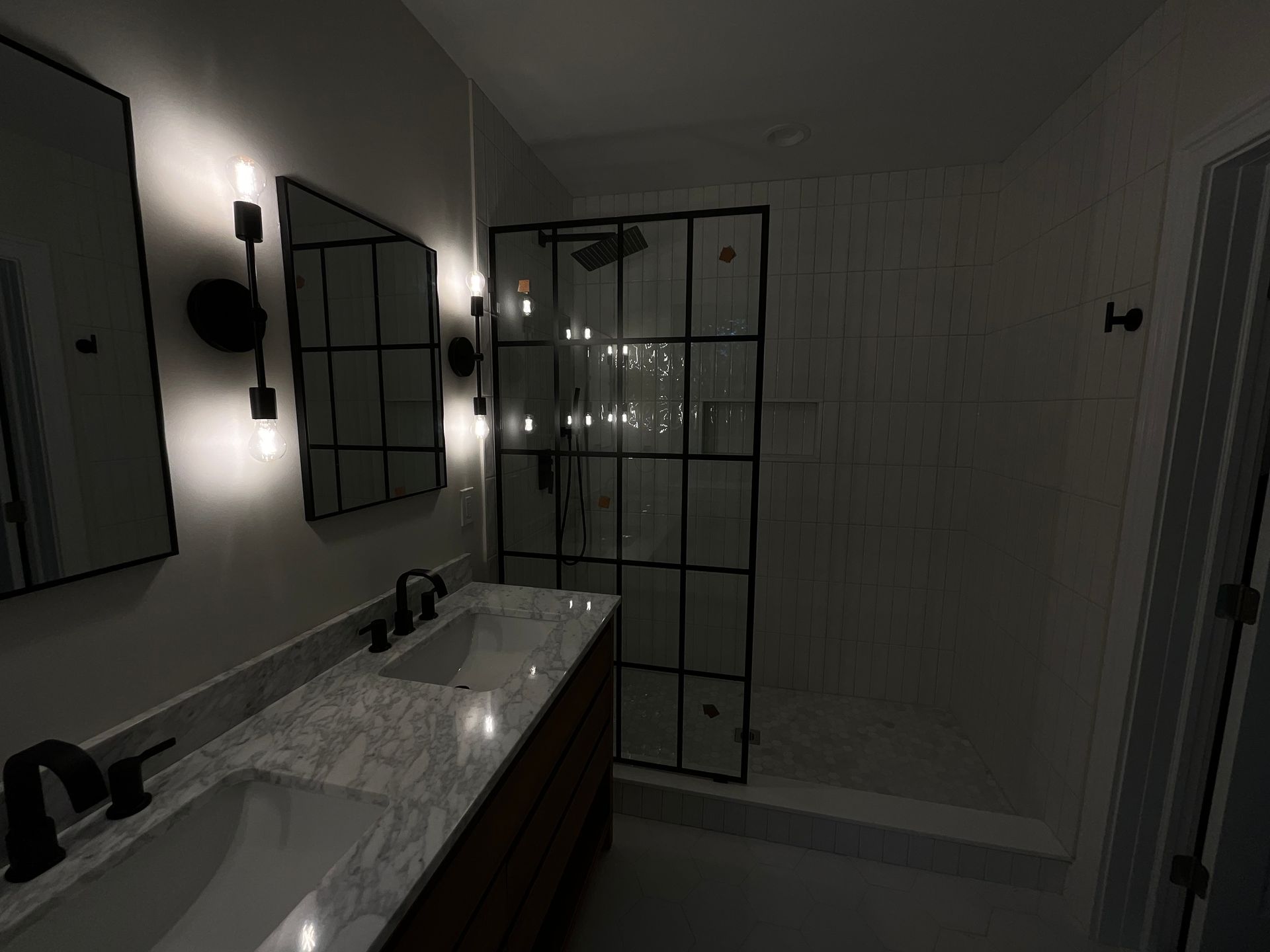 A bathroom with two sinks and a walk in shower.