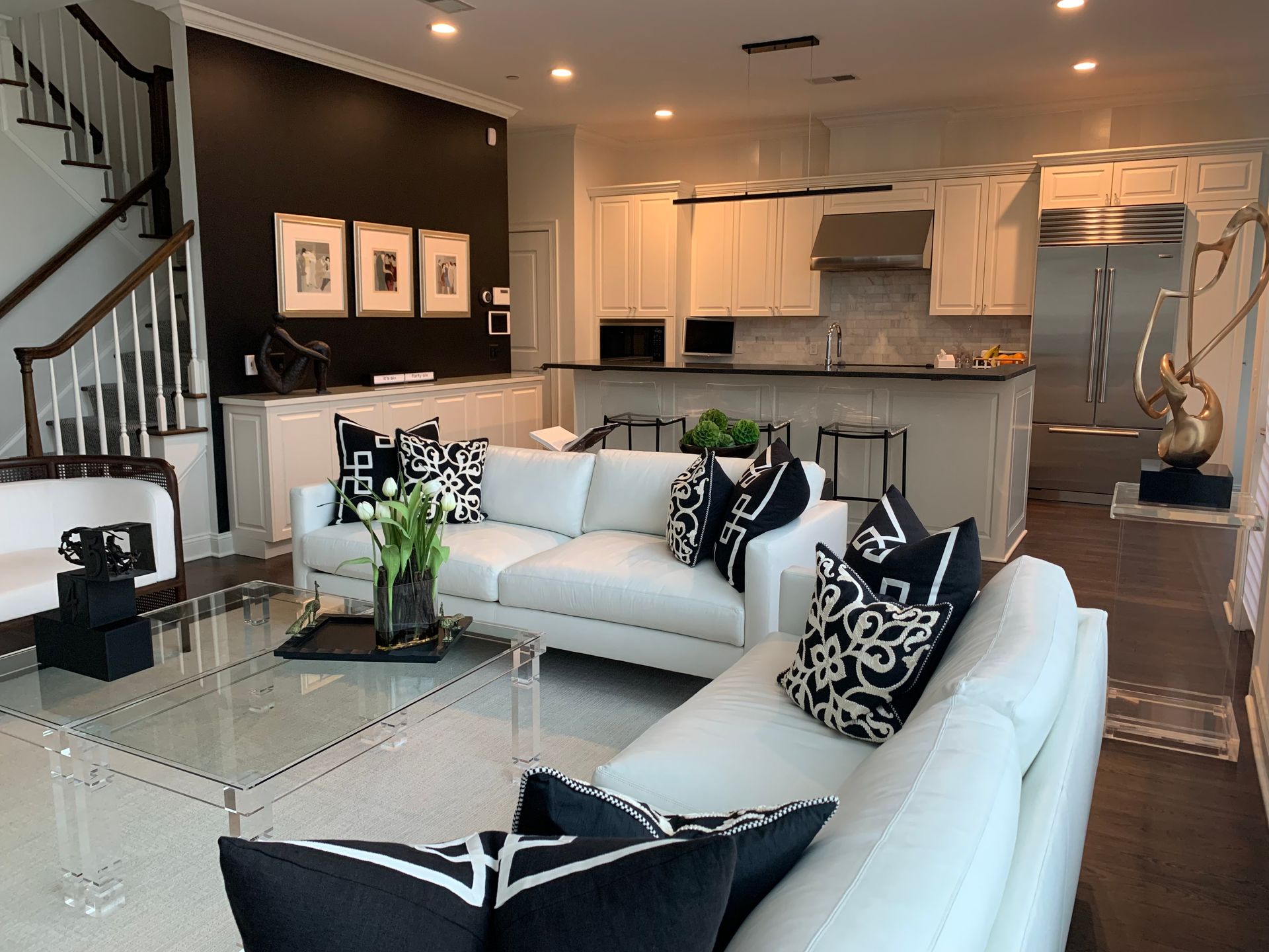 A living room with a white couch and black and white pillows