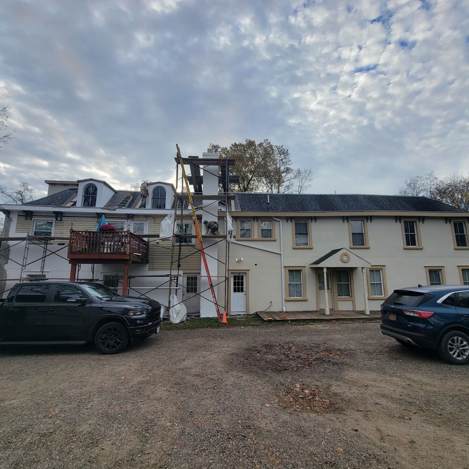 A man is working on a roof with a drill.