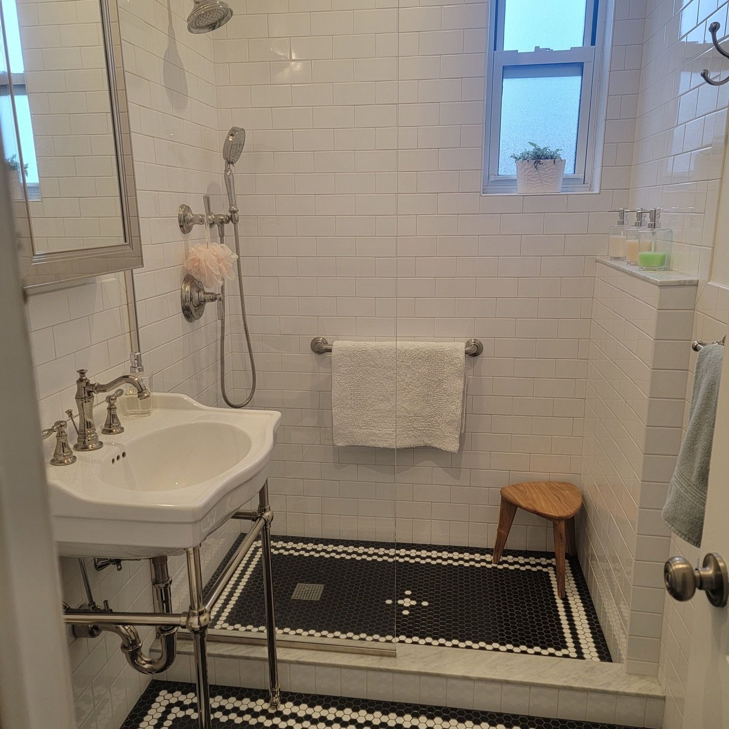A bathroom with a sink a mirror and a shower
