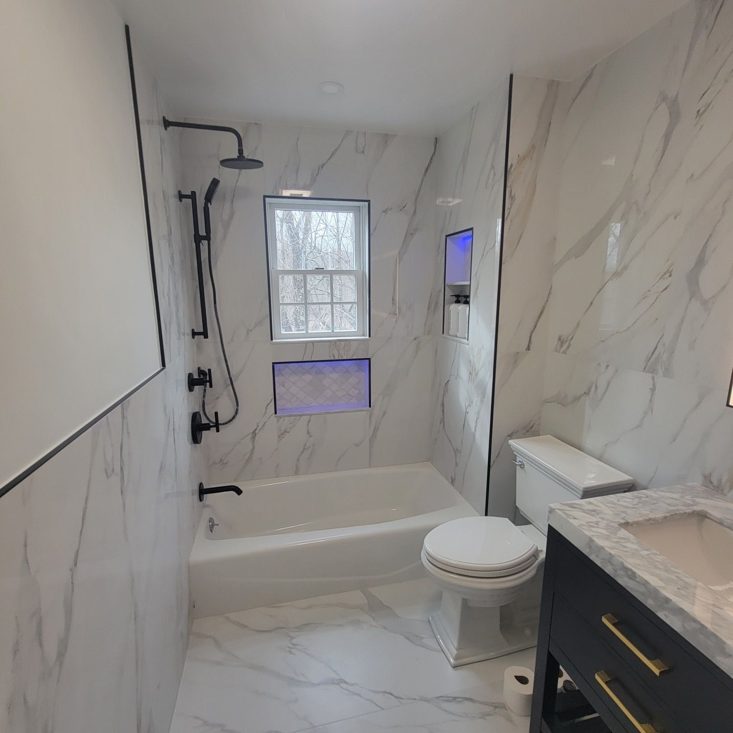 A bathroom with a tub , toilet , sink and shower.
