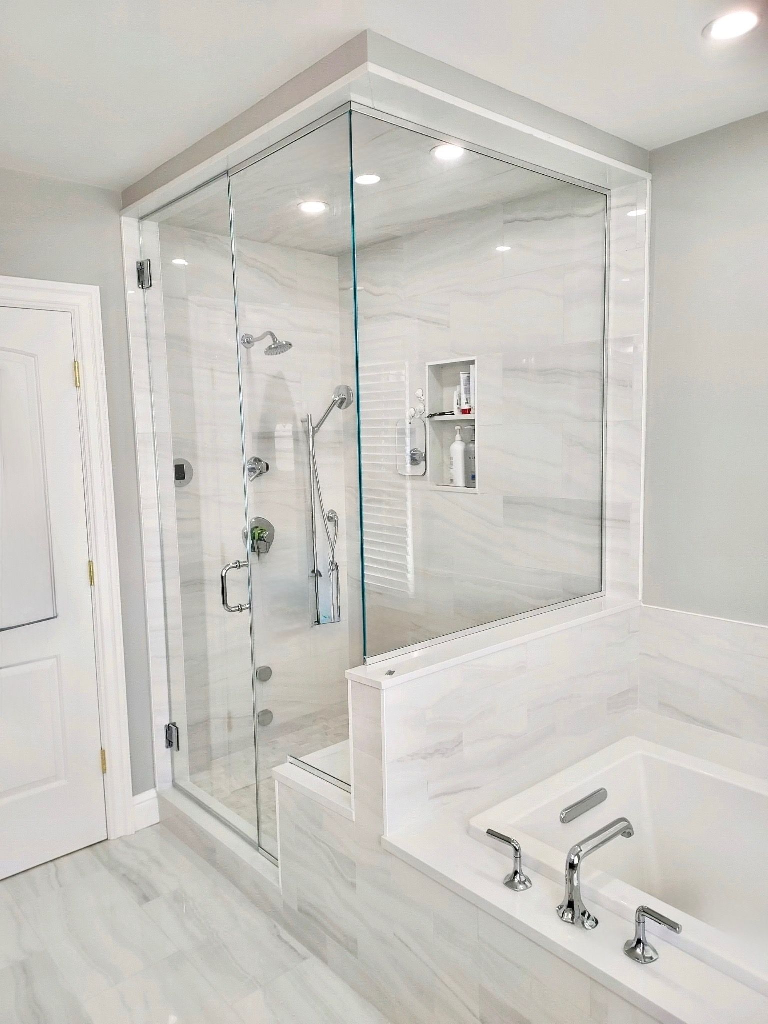 A bathroom with two sinks and a walk in shower.