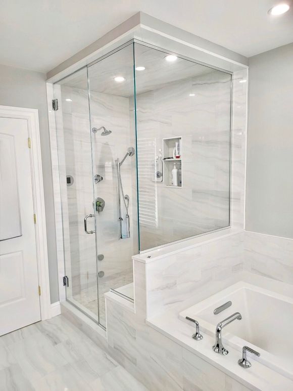 A bathroom with two sinks and a walk in shower.