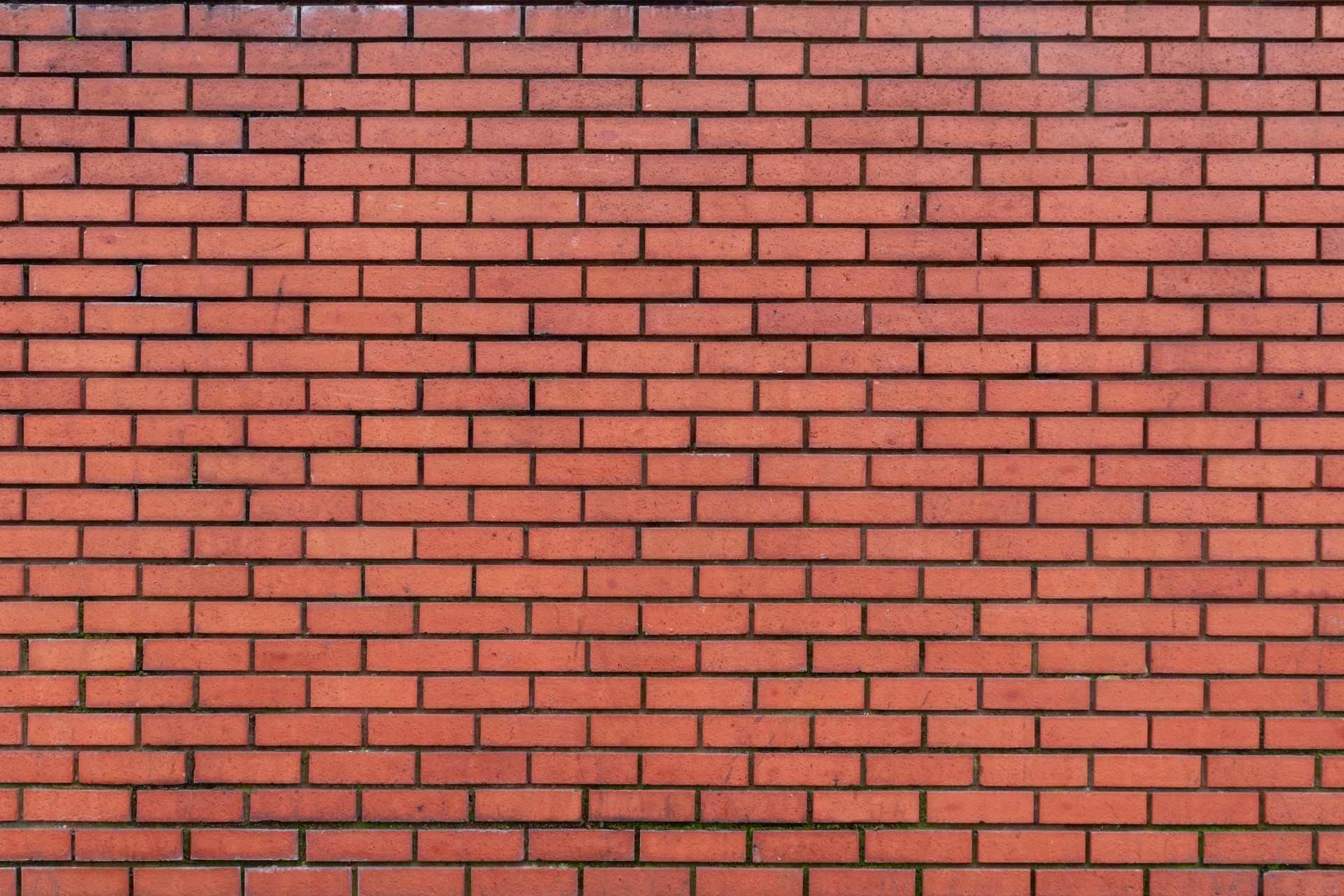 Red brick wall with dark mortar.