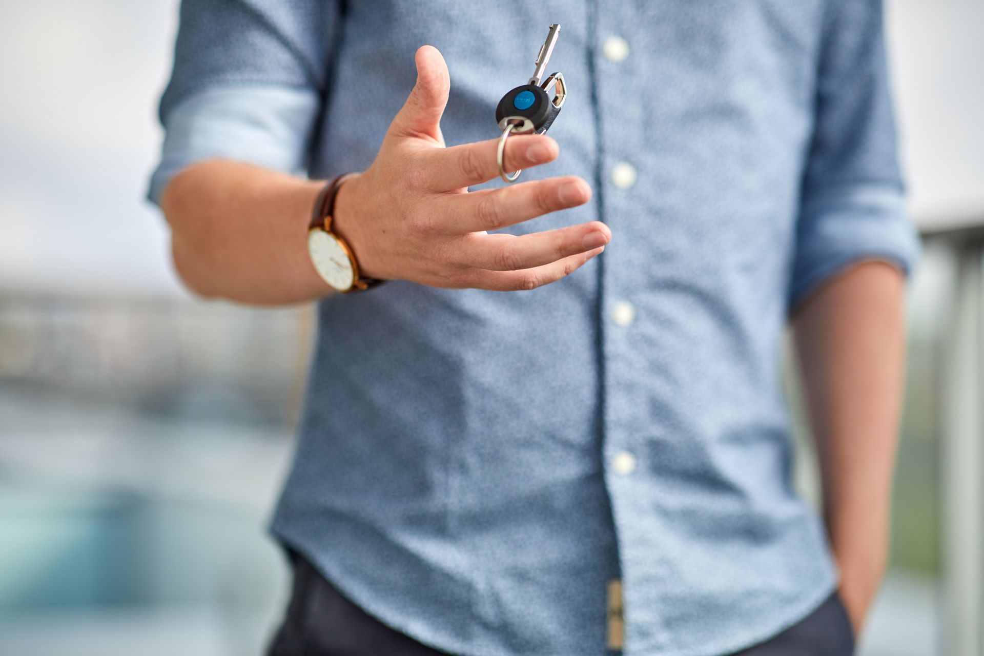 Ein Mann in einem blauen Hemd hält einen iLOQ Schlüssel in der Hand.