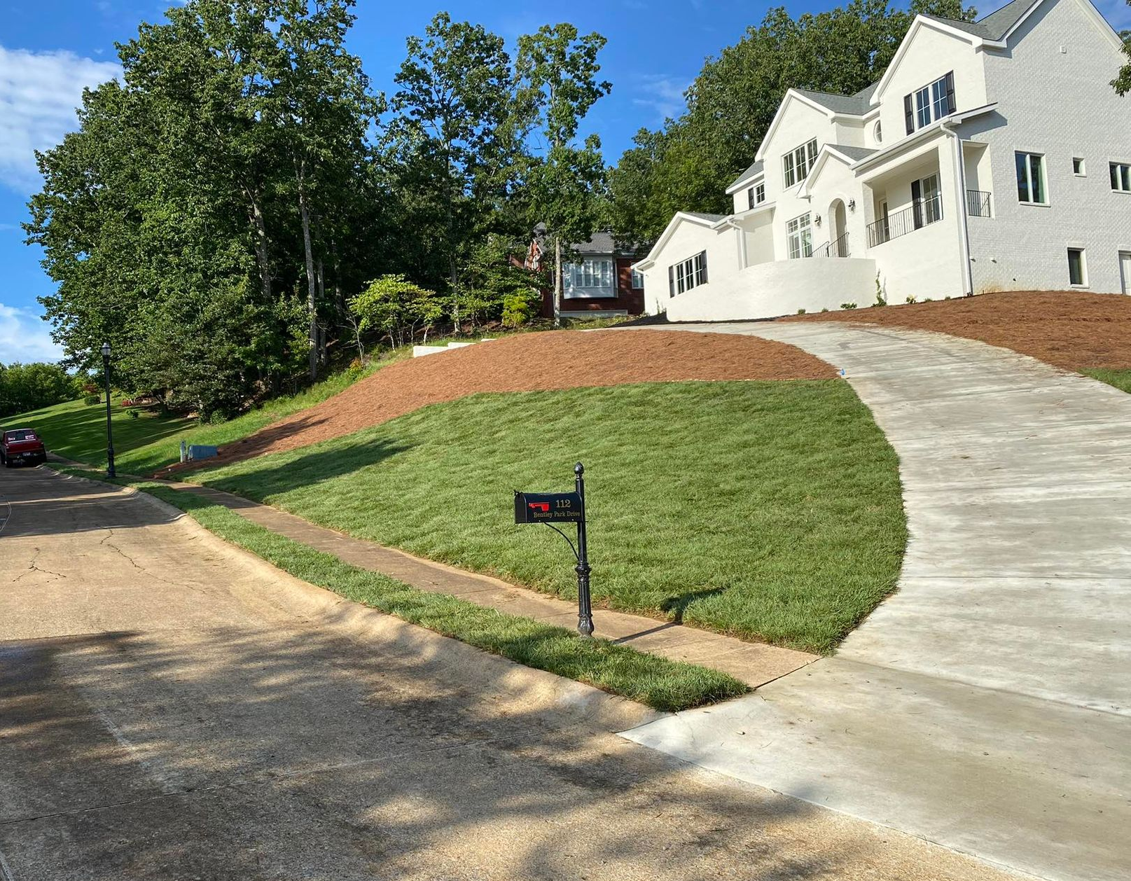 Partially built stone patio and steps beside a house, with gravel and construction materials around it