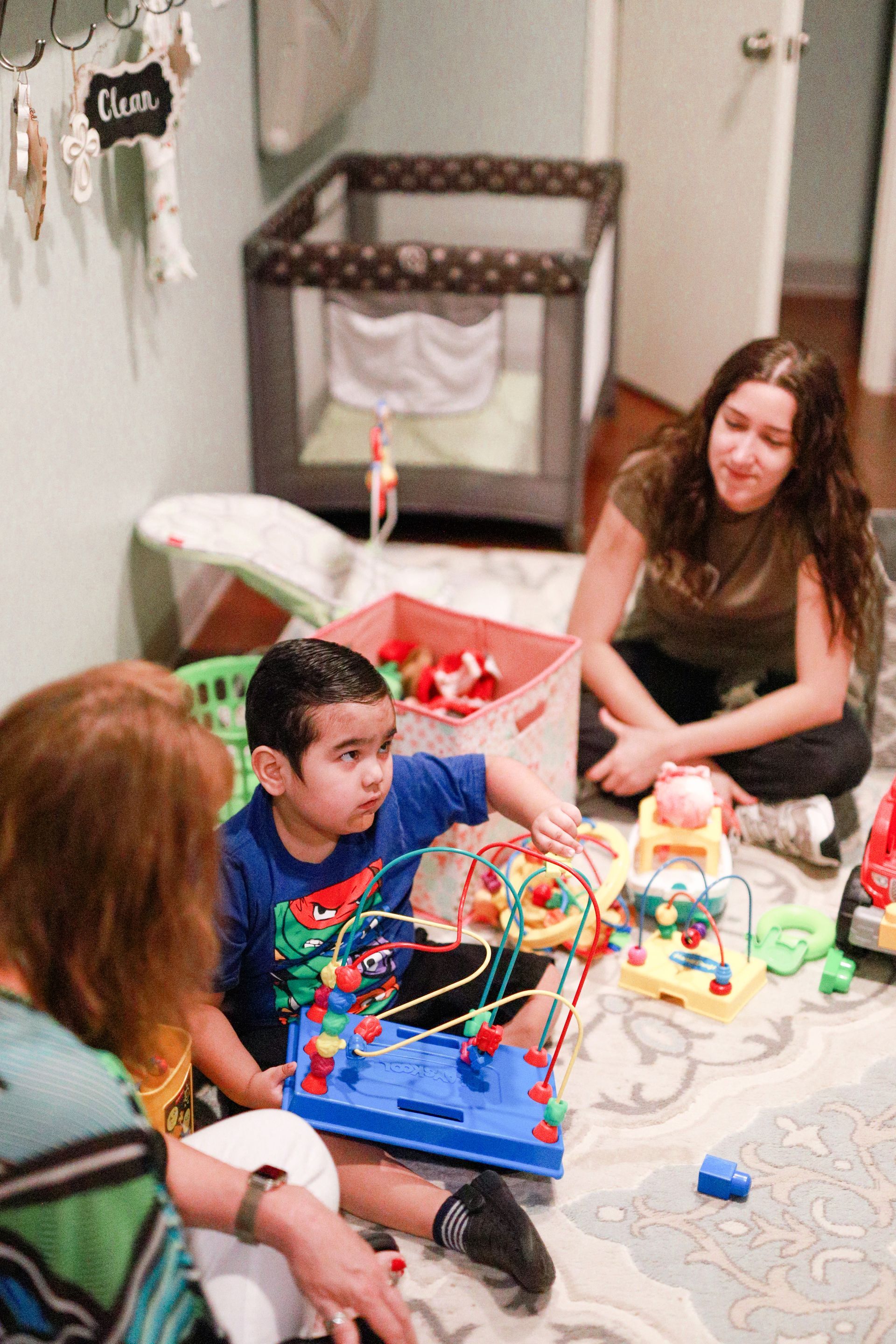 A group of children are sitting at a table painting on paper plates.