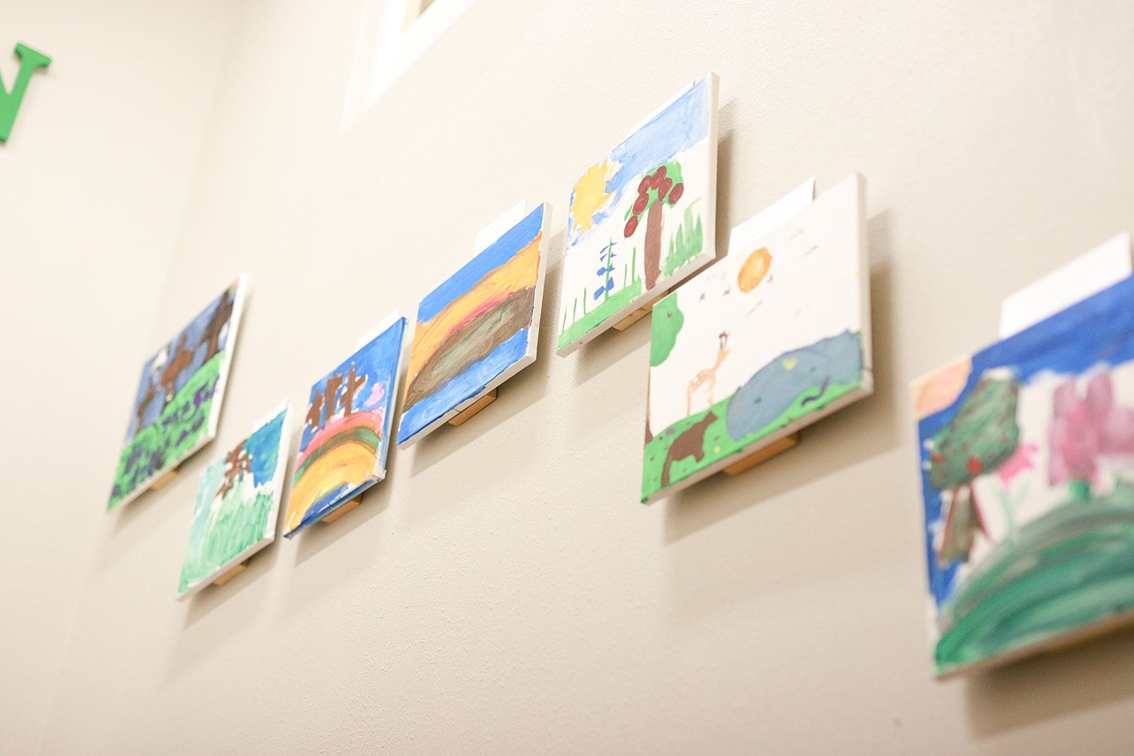 Colorful handprints, hearts, and flowers on canvas.