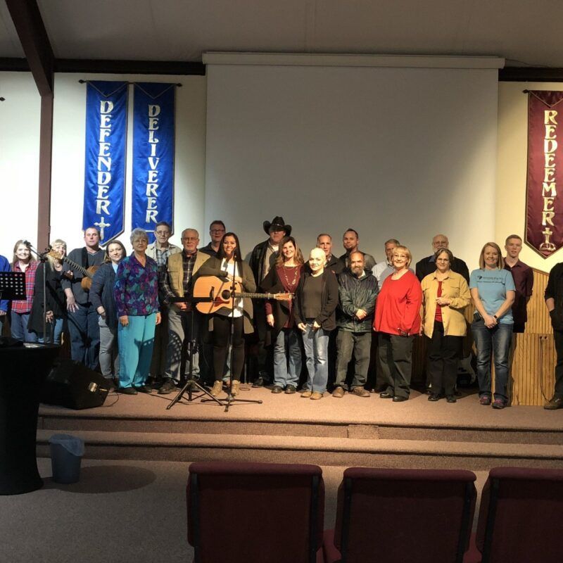 A group of people standing in front of a banner that says deliverer