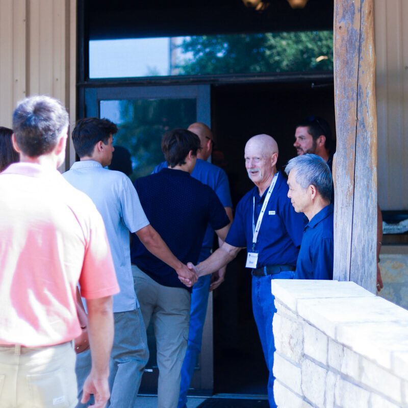 A group of people standing outside of a building holding hands