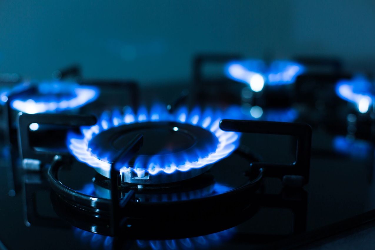 Quemadores de una cocina de gas azul encendidos en una cocina oscura