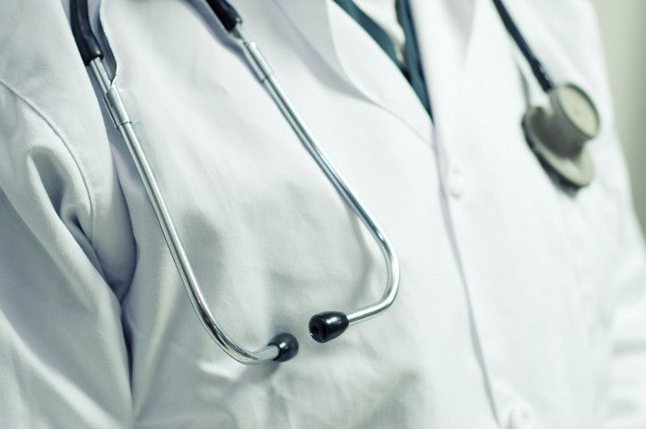 A close up of a doctor 's coat with a stethoscope around his neck.