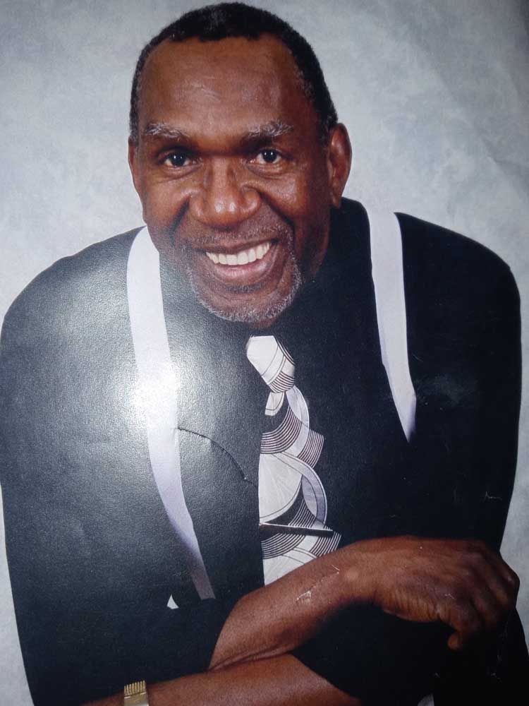 A man in a suit and tie is smiling for the camera