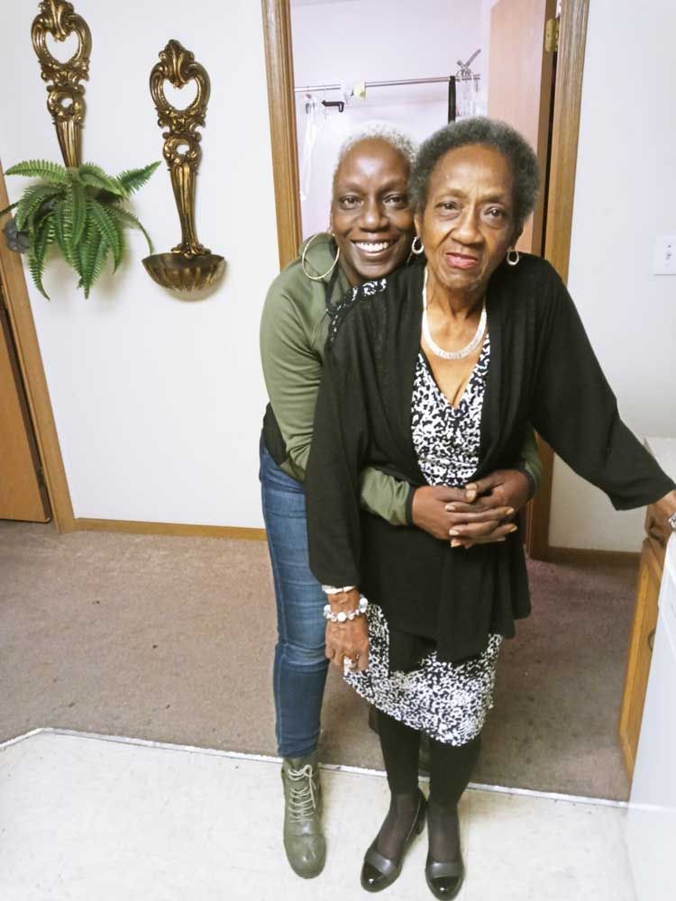 A woman is hugging an older woman in a hallway
