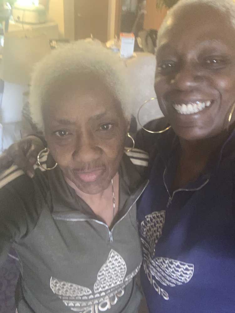 Two older women are posing for a picture together and smiling.