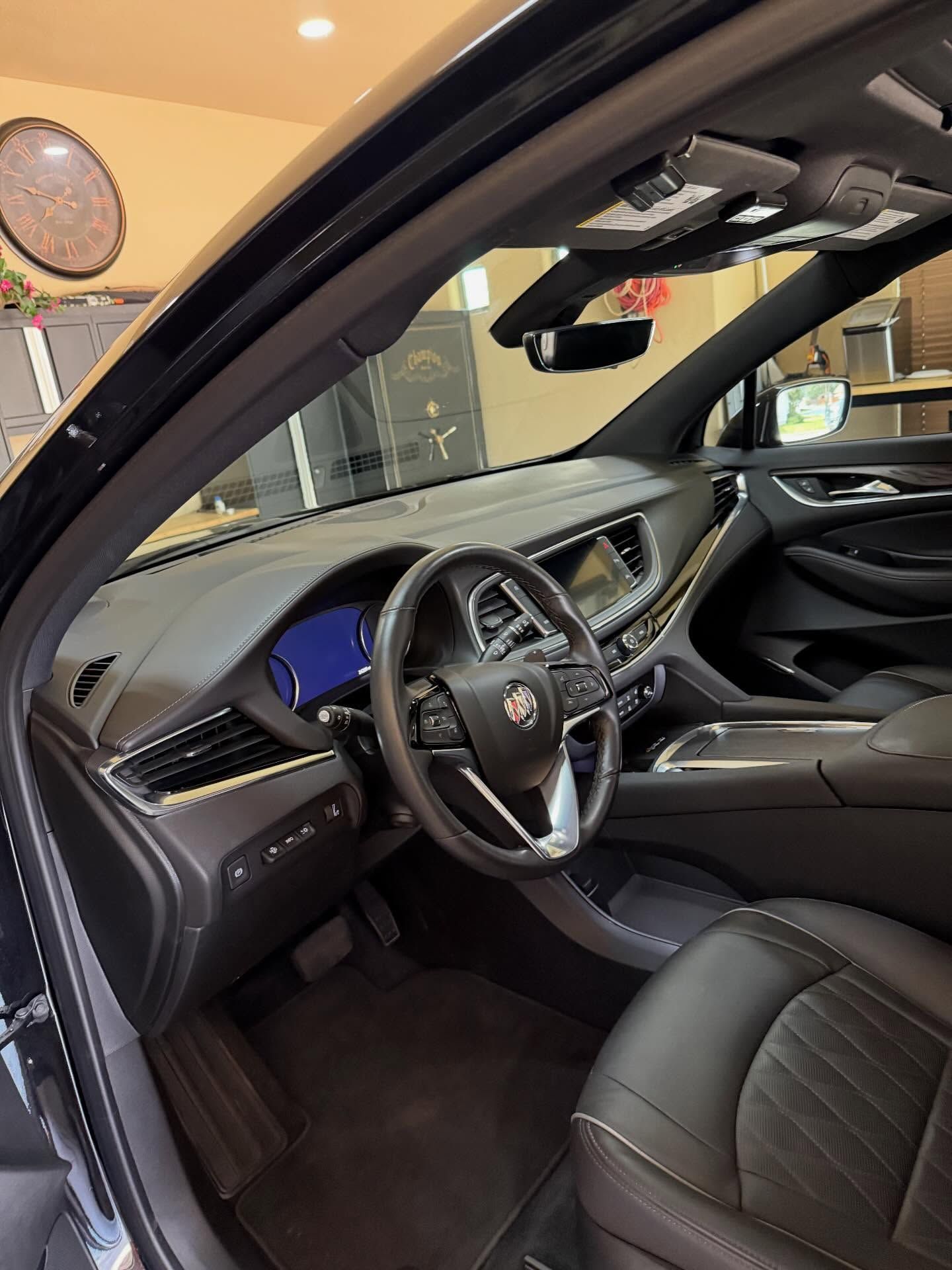 Black luxury SUV interior with leather seats, dashboard, steering wheel, and sunroof visible