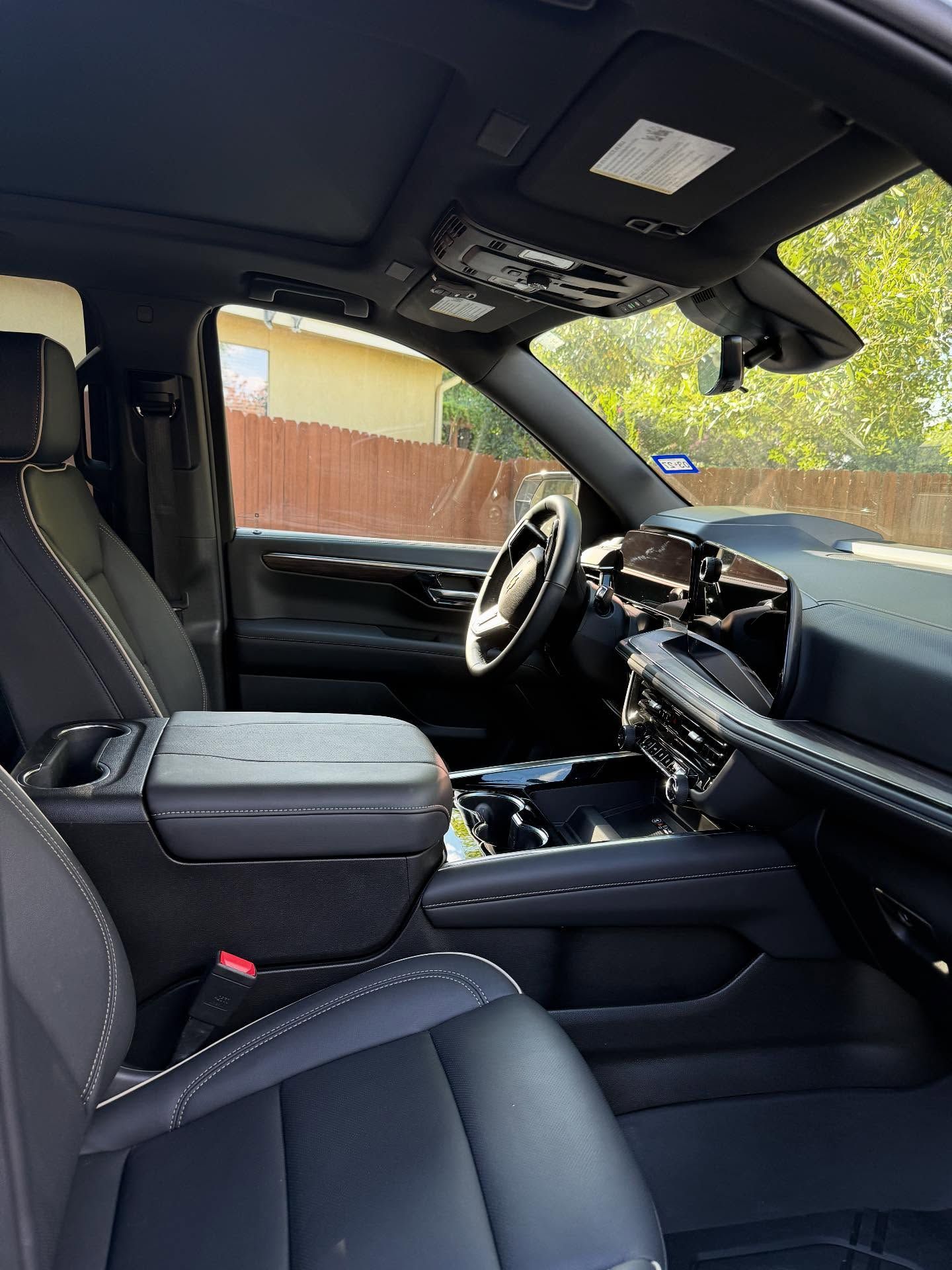 Front interior of a black SUV with leather seats, center console, and steering wheel visible.