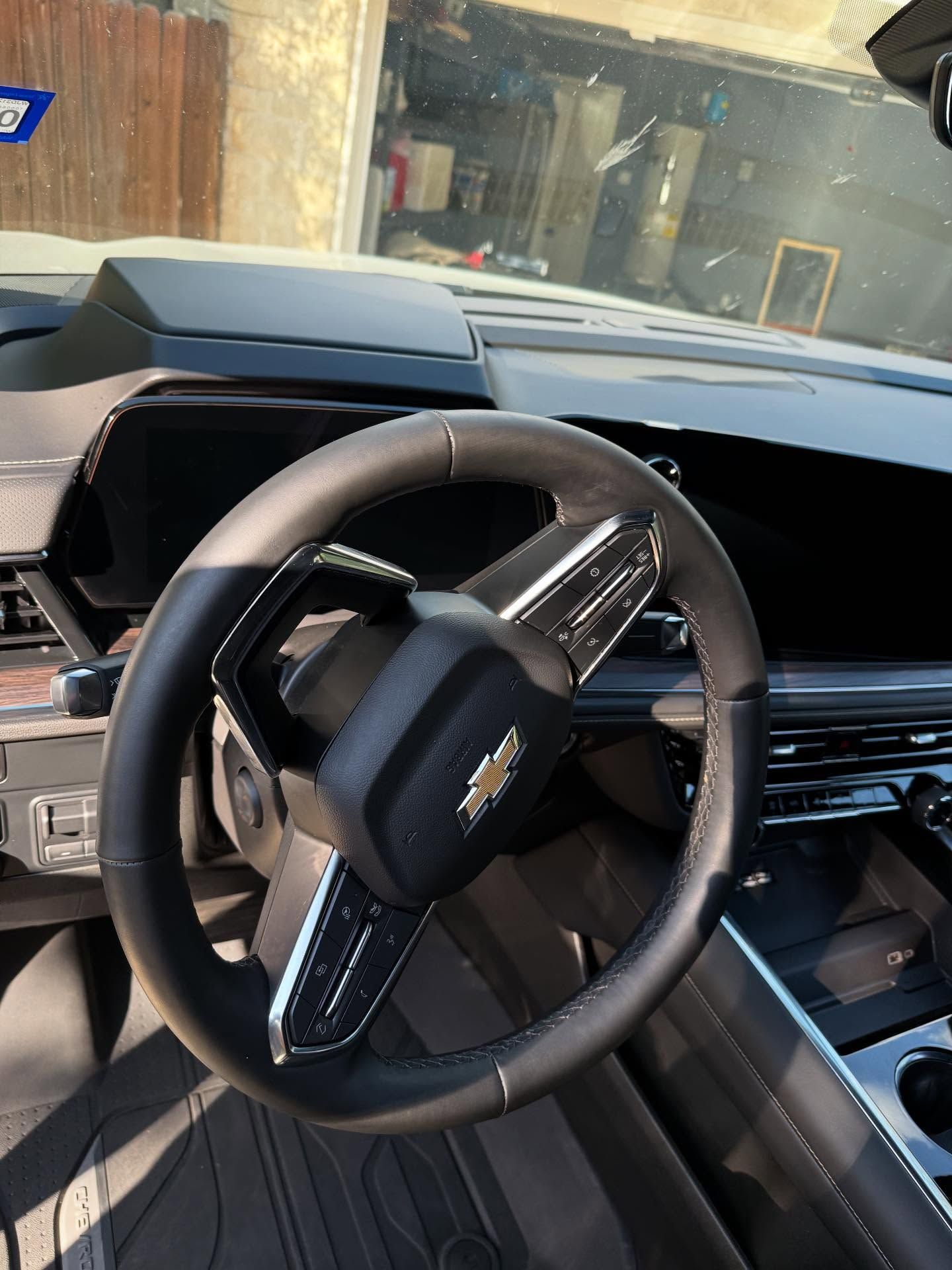 Car interior showing a black steering wheel and dashboard in a luxury vehicle