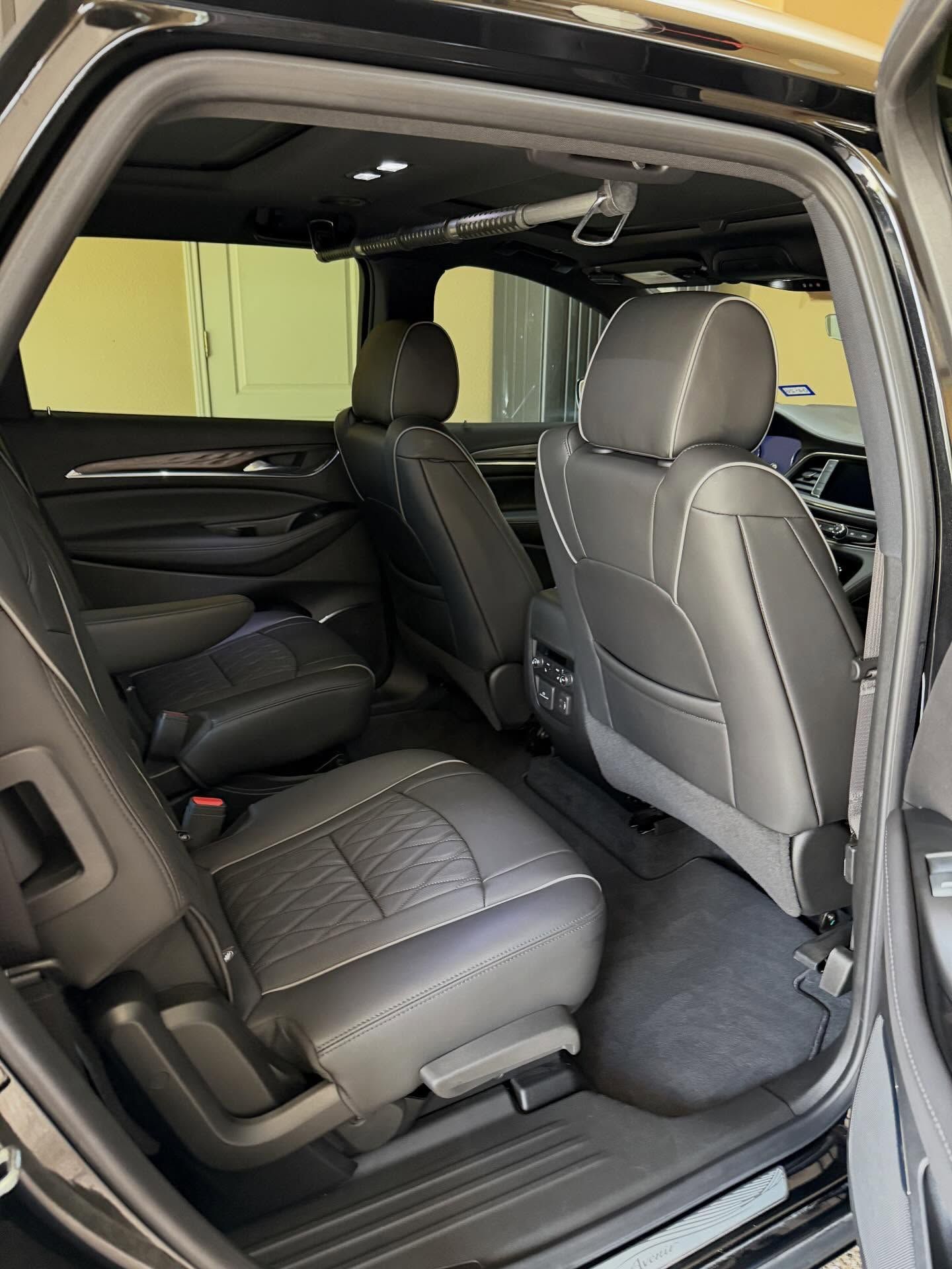 Spacious SUV rear seats with black leather upholstery and seatbacks folded down in an interior view
