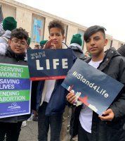 Three protesters holding anti-abortion signs, including 