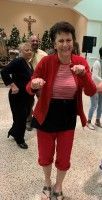 Woman in red jacket and leggings posing with fists up in a living room