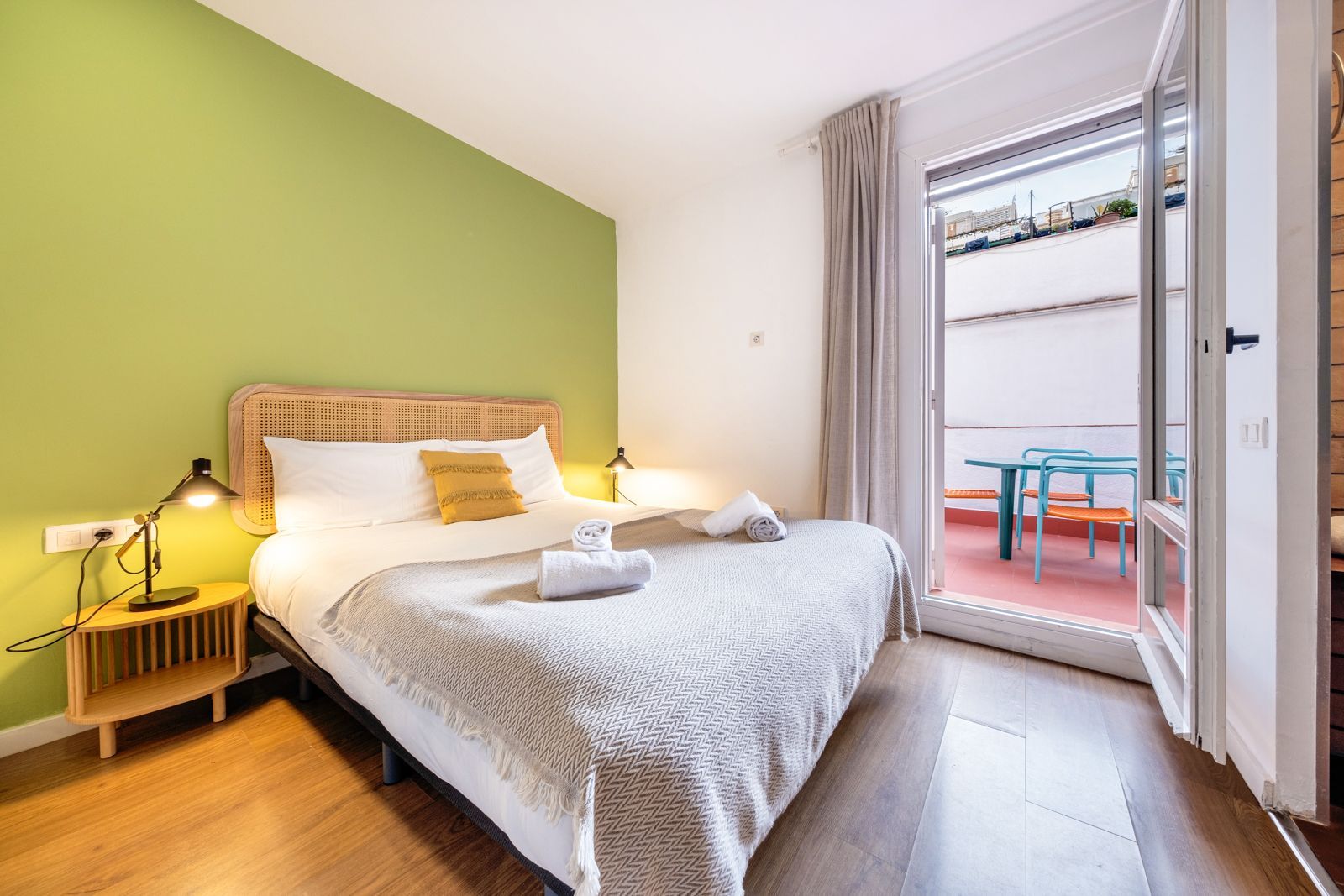 A bedroom with a king size bed and a balcony.