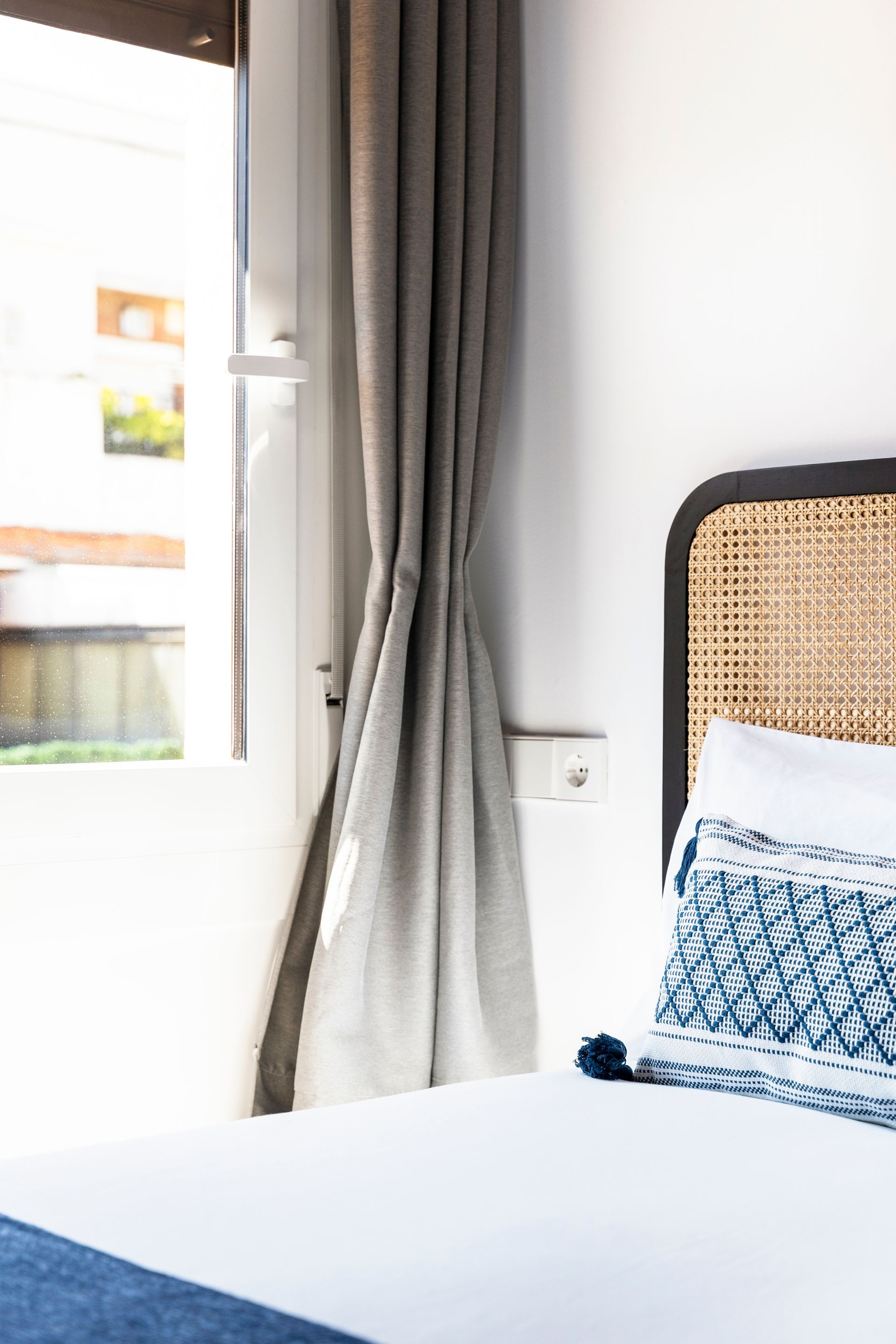 A bedroom with a bed and a window with curtains.