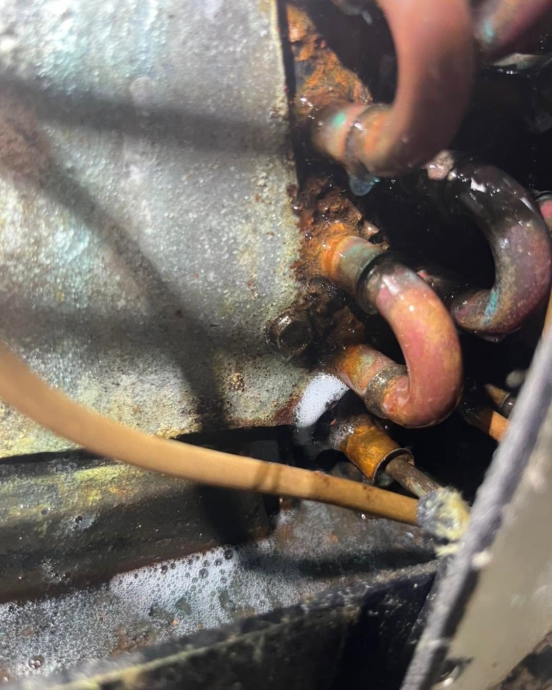 Rusty metal chain links with a tan cable crossing in a close-up industrial scene