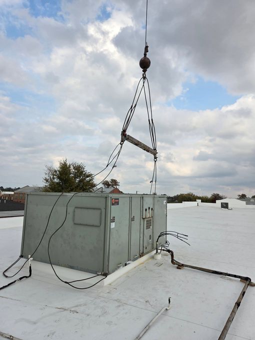 Snow-covered rooftop with a gray utility box and a tall antenna mast under a cloudy sky