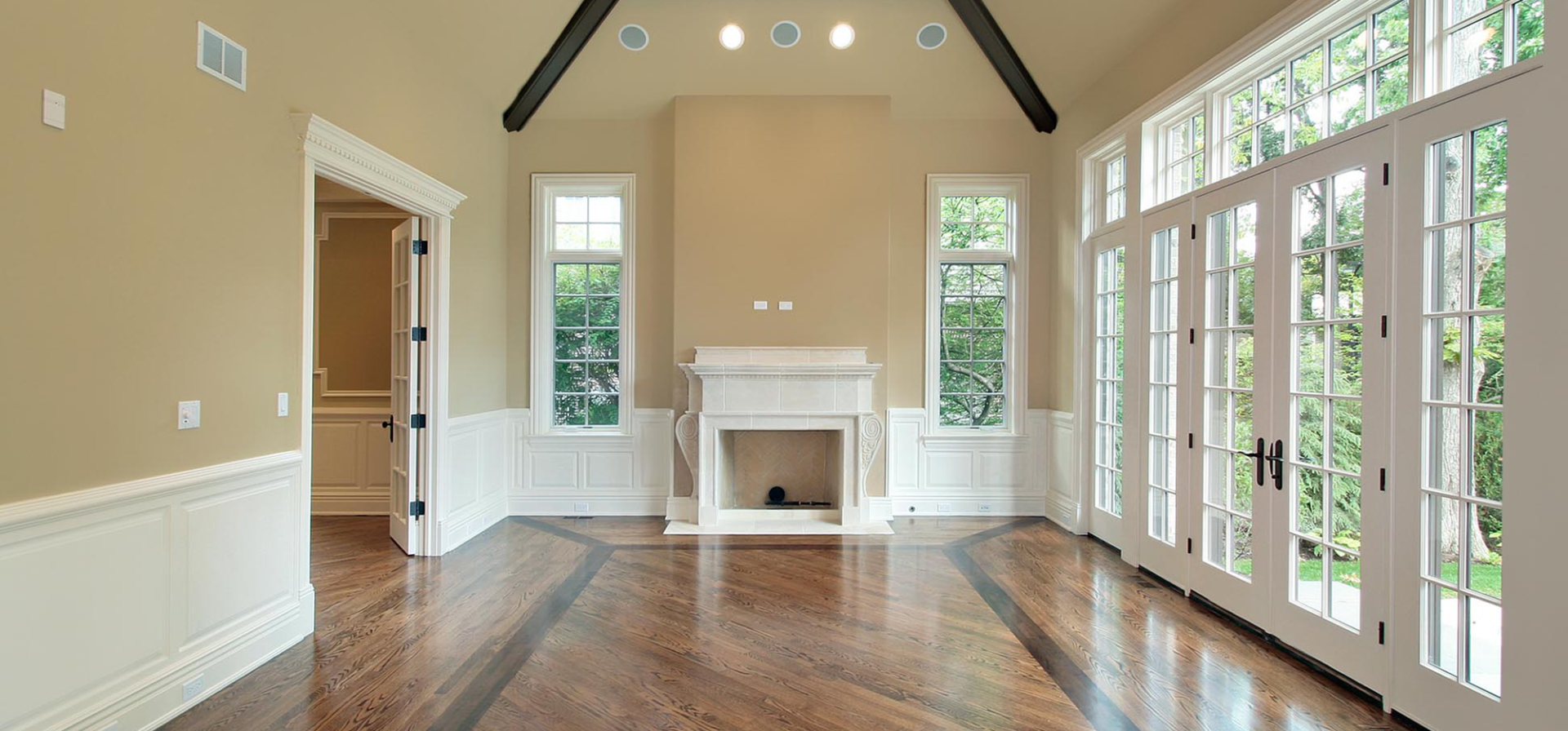 An empty living room with a fireplace and lots of windows.