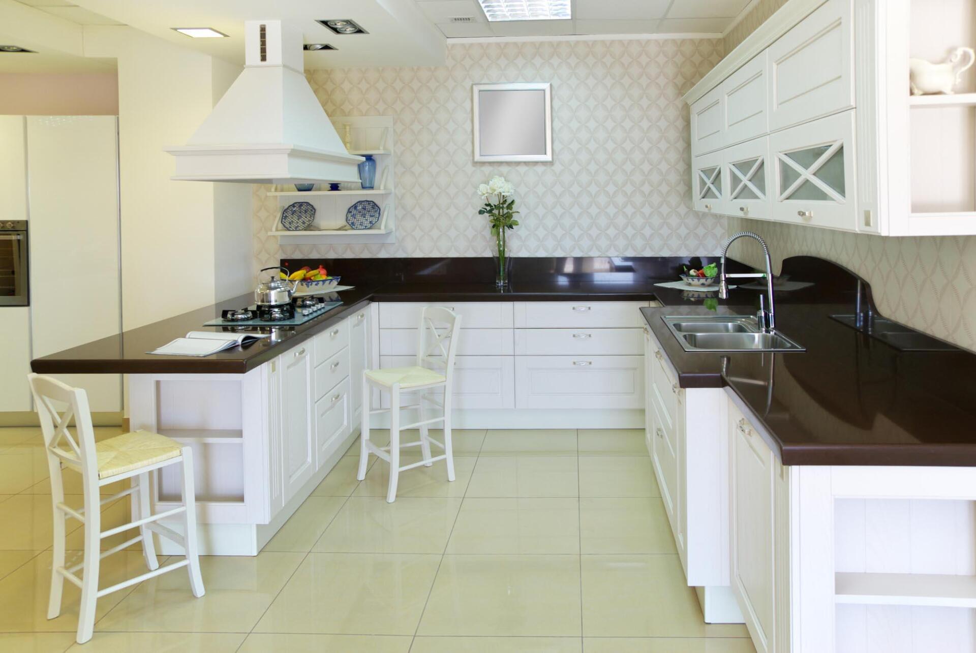 A kitchen with white cabinets and black counter tops