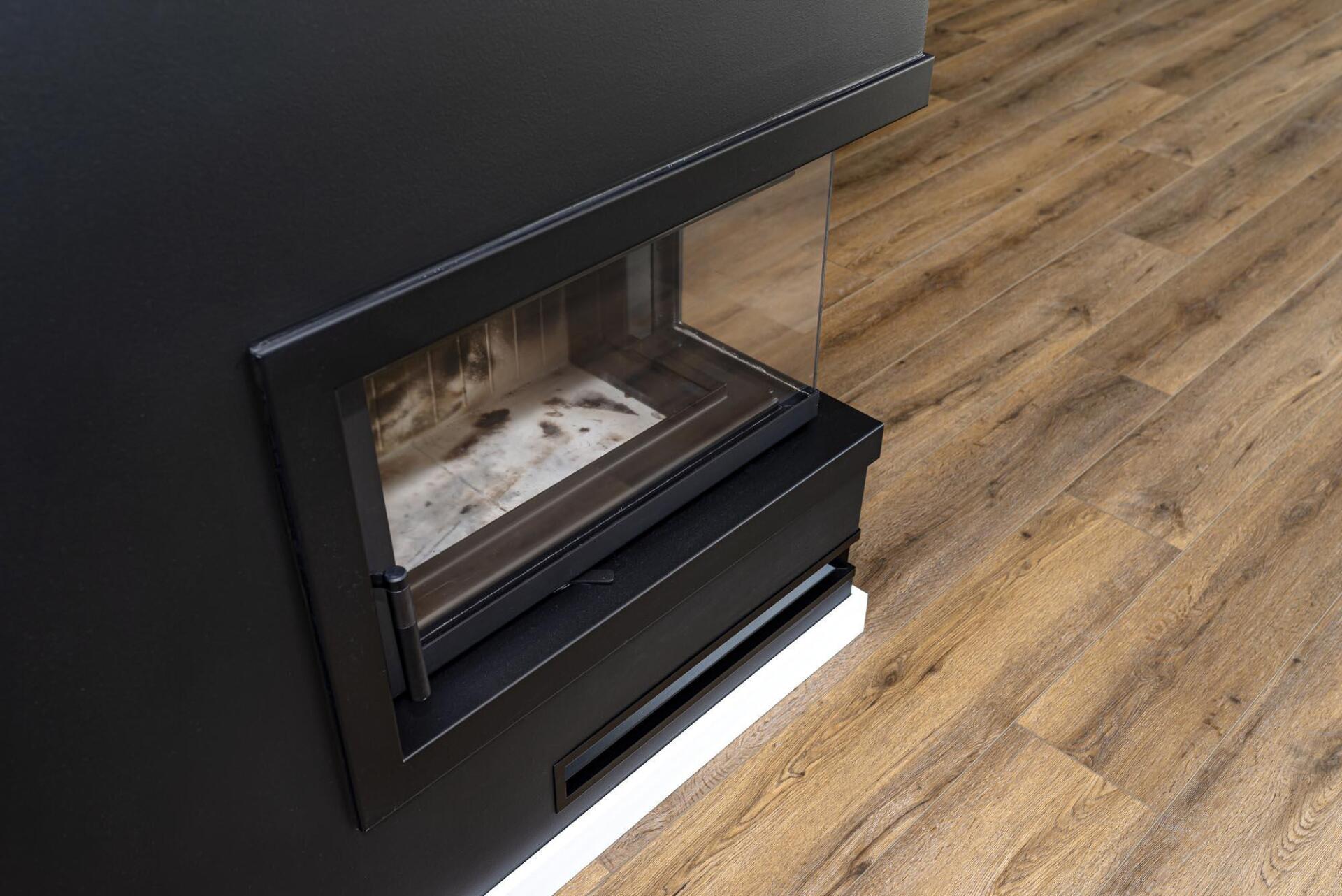A fireplace with a wooden floor in a living room.