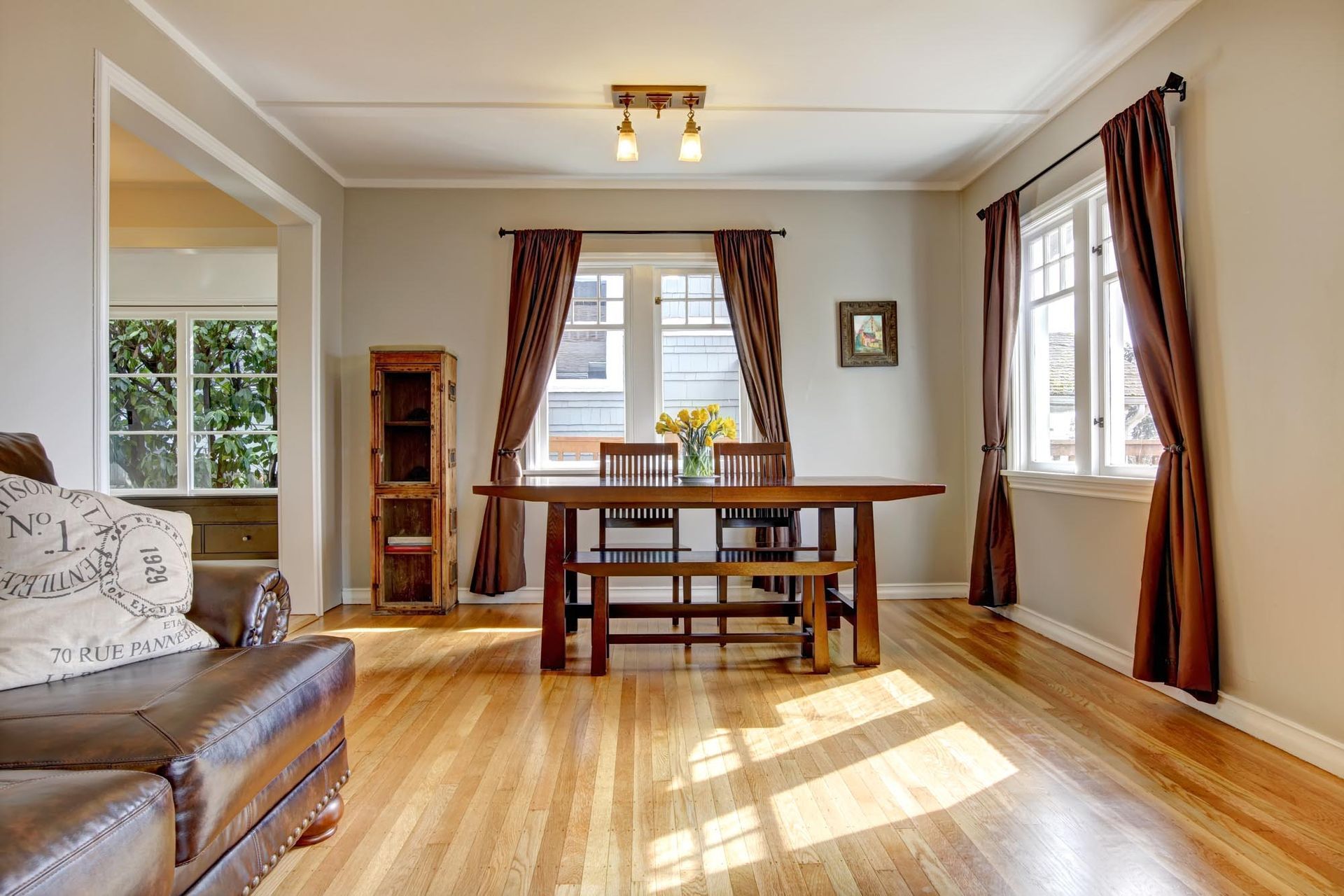 A living room with hardwood floors and a dining room table