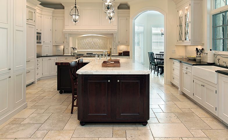 A kitchen with white cabinets and a large island in the middle.