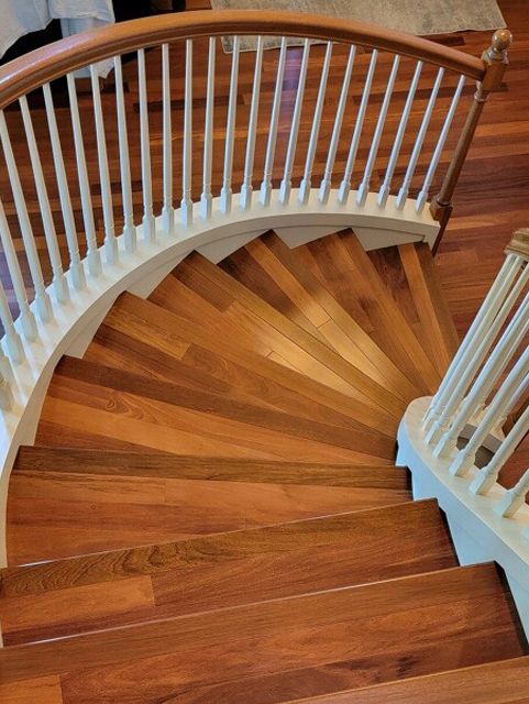 A wooden spiral staircase with a white railing