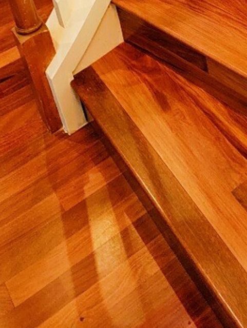 A close up of a wooden staircase with a white railing.