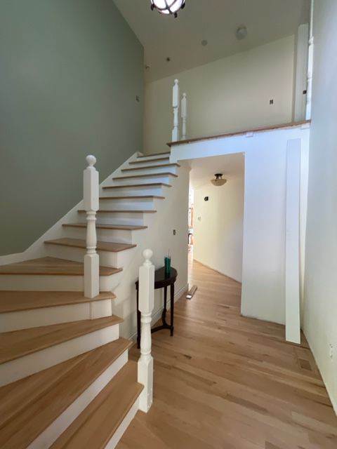 A hallway with stairs leading up to the second floor