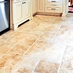A kitchen with a tile floor and white cabinets