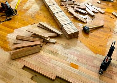 A wooden floor is being installed with tools on it.