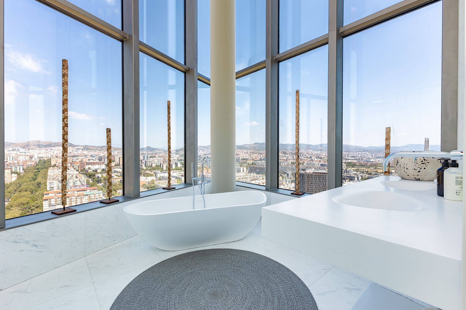 Baño de diseño con bañera exenta y vistas urbanas