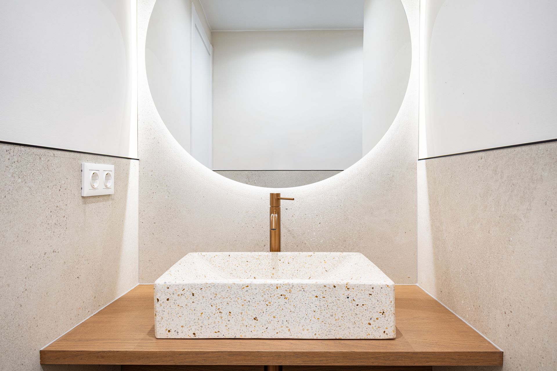 Baño de diseño con lavabo de piedra en piso reformado de Barcelona