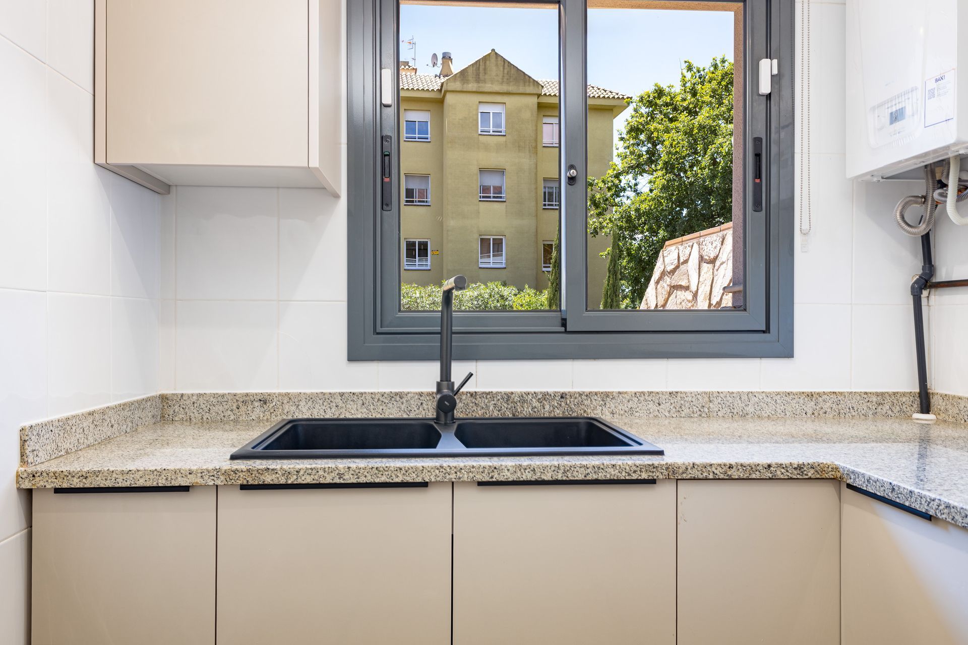 Cocina reformada con encimera de granito en piso de Blanes