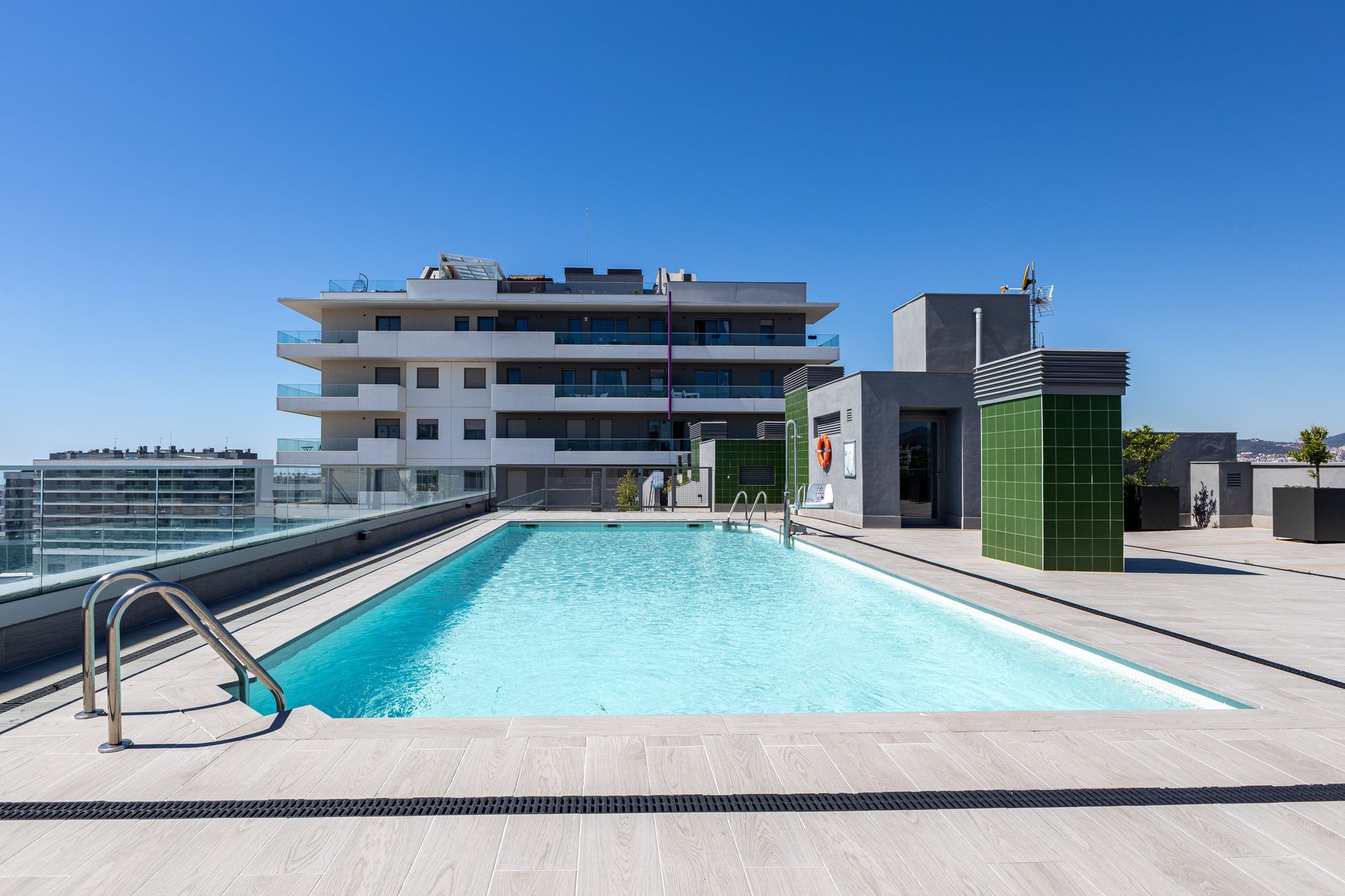 Piscina comunitaria en edificio residencial de Badalona con solárium